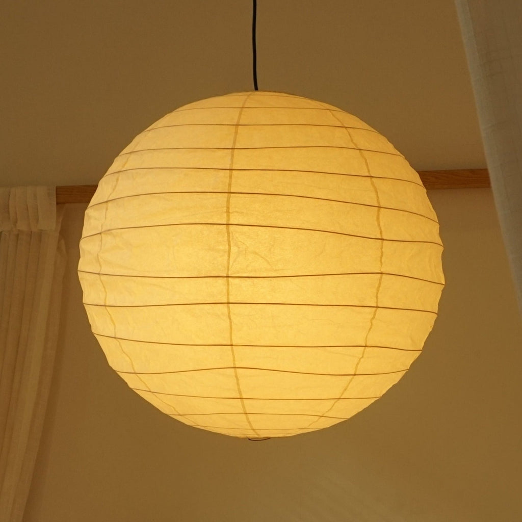 Hüga Collective Akari handmade paper ceiling lamp with light on. In bedroom lighting. 
