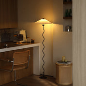 Pleated floor lamp lit in a living room corner
