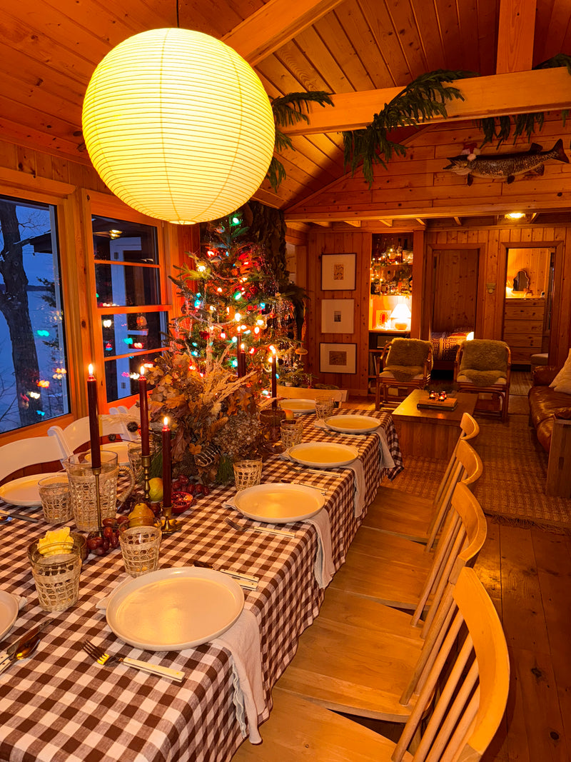 Luna washi paper pendant glowing above a long holiday table set for a crowd