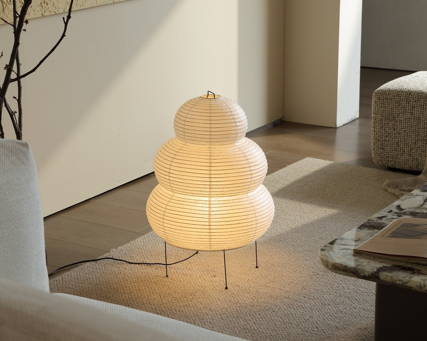 Kumo washi paper floor lamp lit, glowing softly in the same living room corner