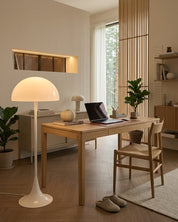 Mushroom floor lamp lit beside a desk in a home office