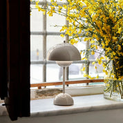 Grey beige Flowerpot cordless table lamp next to yellow flowers