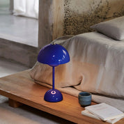 Navy Flowerpot rechargeable lamp on a bedroom nightstand